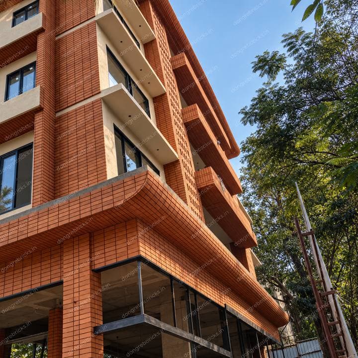 Brick-clad building using bullnose units on curved corners and slab edges