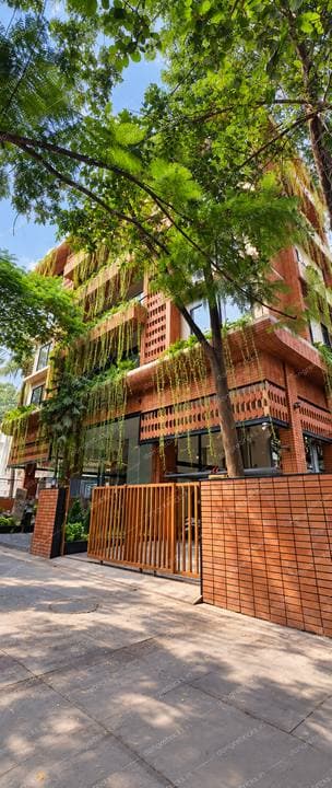Same building from the street, brick boundary wall and gate