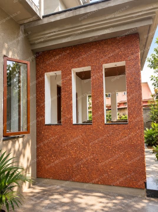Laterite wall with punched window openings onto a courtyard