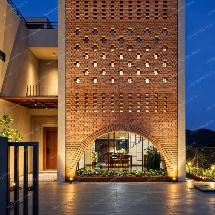 Residence at dusk: tall perforated brick screen over a large arch